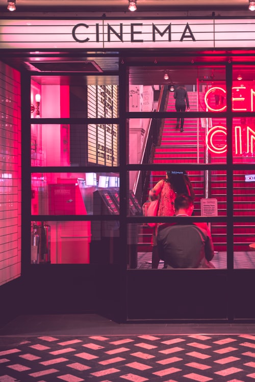 热门动作电影海报，主角持枪站在城市夜景中